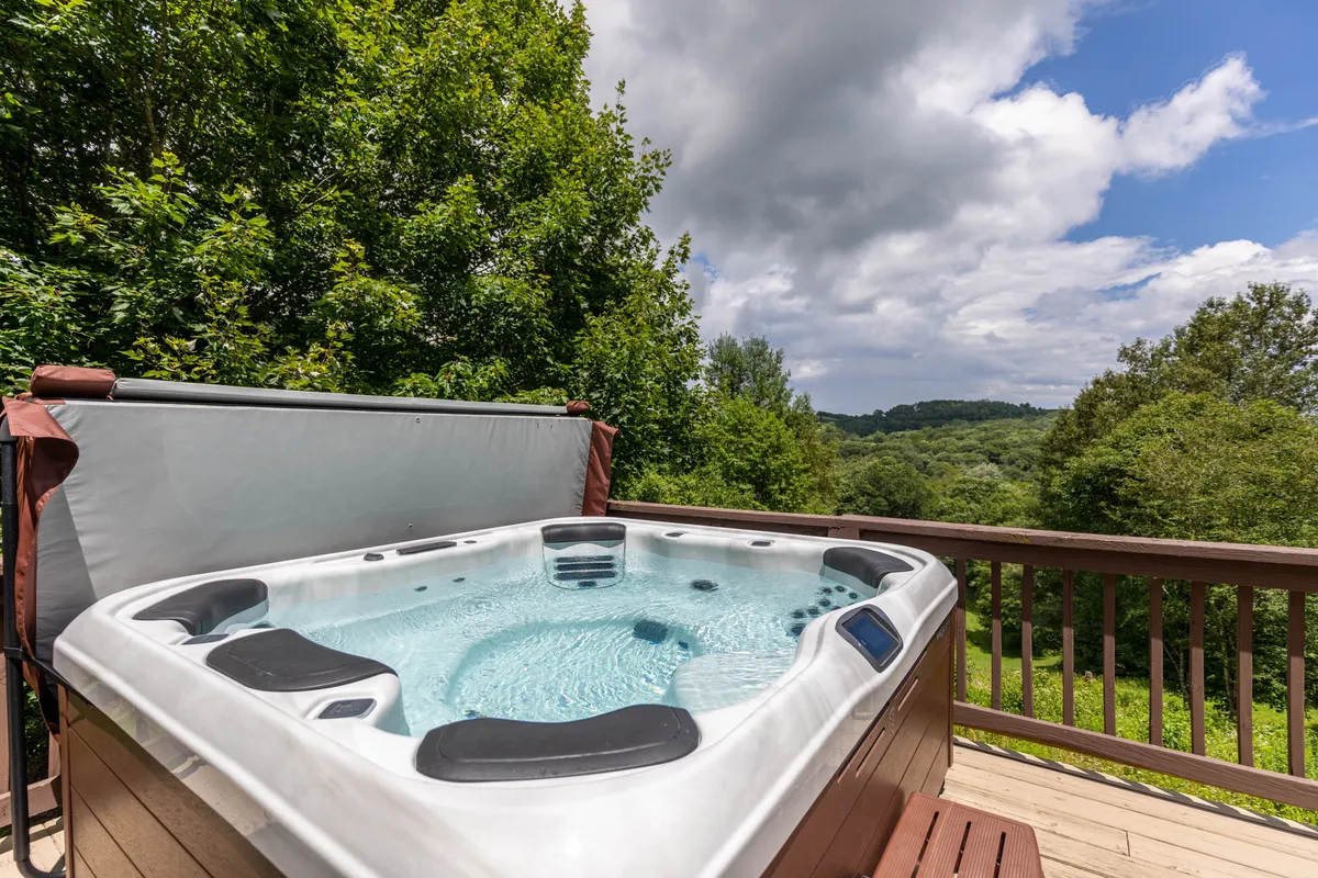 This image centers on a hot tub on the deck, surrounded by greenery and a sturdy railing. The tranquil environment creates an appealing space to unwind after a day of exploring with pets or enjoying the nearby parks.